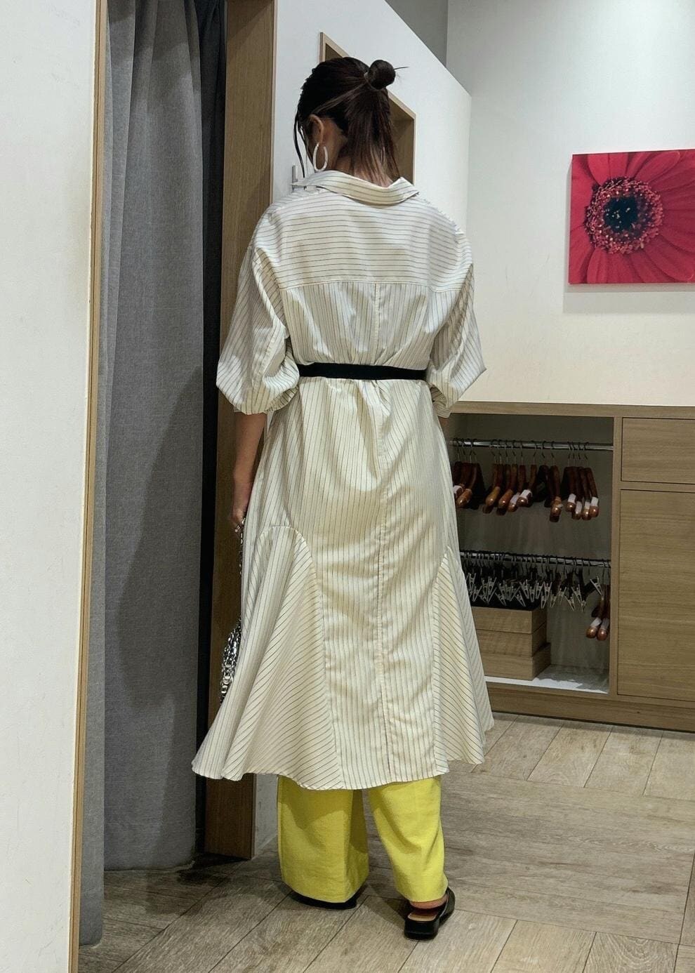 イエロー系のシャツワンピース、イエロー系のスラックス、シルバー系のショルダーバッグを着用したレディースの春コーディネートの2枚目の写真