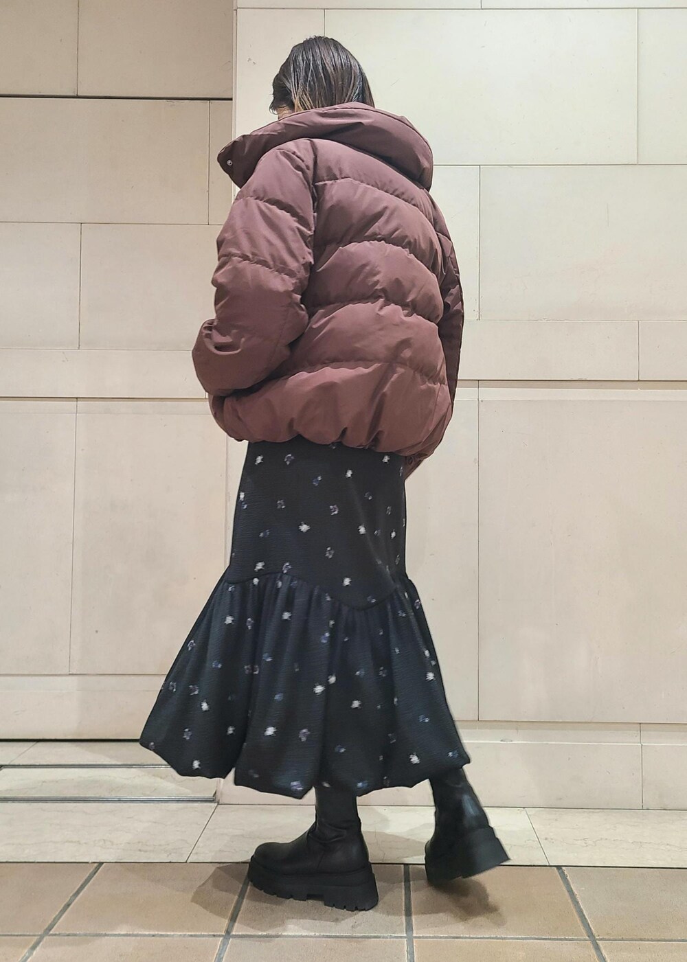 ブラウン系のダウンジャケット/コート、ブラック系のショルダーバッグ、イエロー系のニット/セーターを着用したレディースの冬コーディネートの3枚目の写真