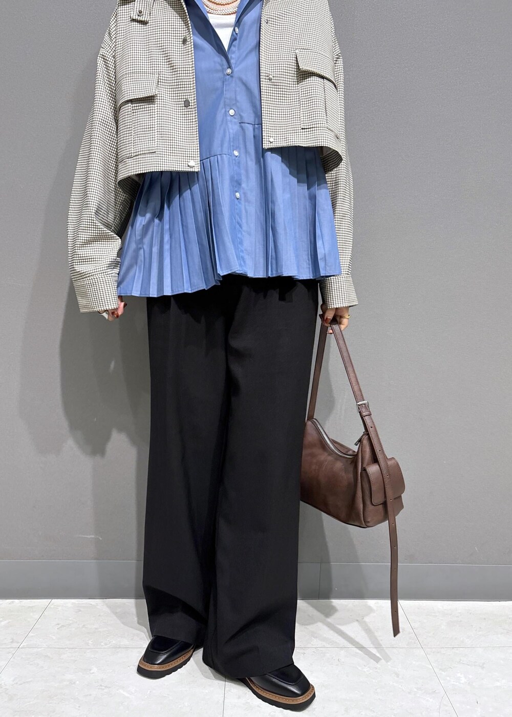 ブラック系のローファー、ブルー系のシャツ/ブラウス、ベージュ系のカバーオールを着用したレディースの秋コーディネートの10枚目の写真