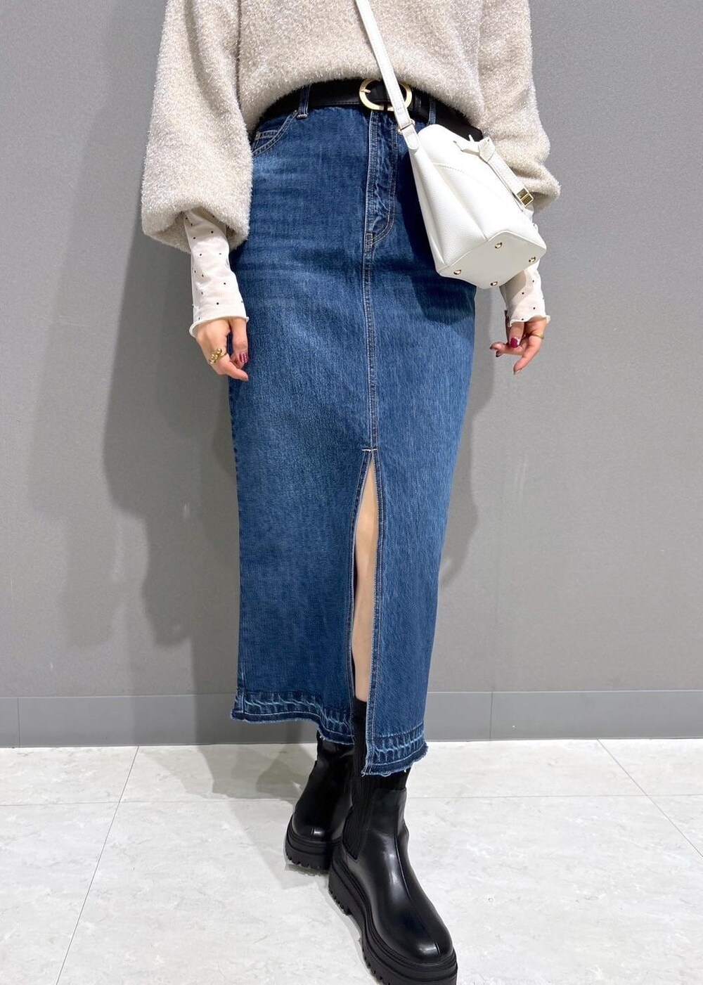 ホワイト系のショルダーバッグ、ブラック系のブーツ、ホワイト系のTシャツ/カットソーを着用したレディースの冬コーディネートの8枚目の写真