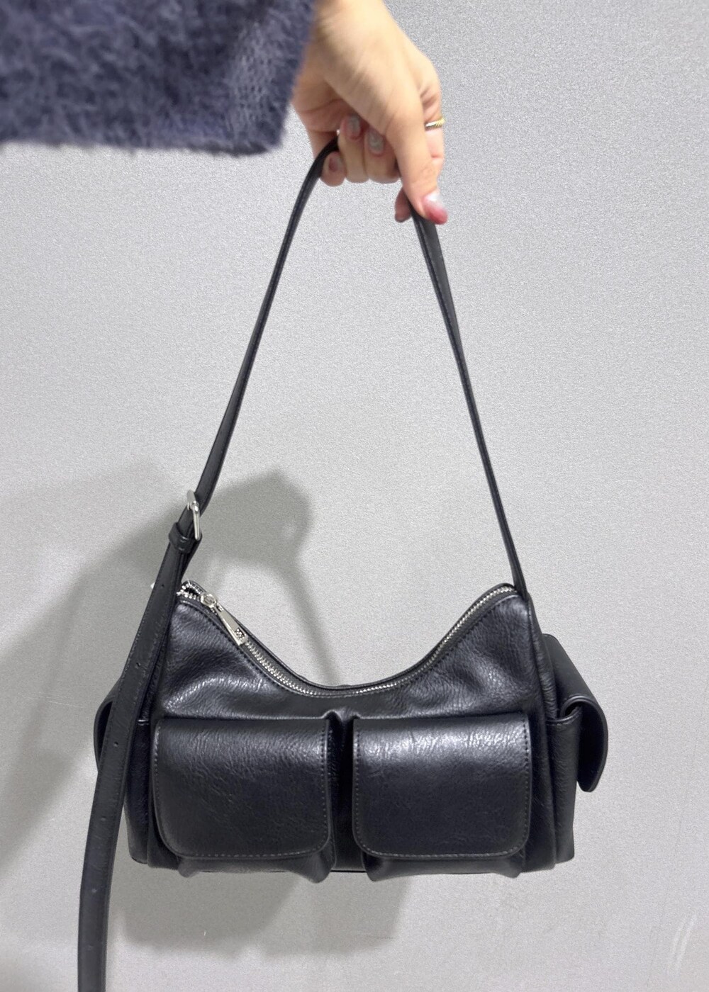 グレー系のニット/セーター、グレー系のスカート、ブラック系のショルダーバッグを着用したレディースの秋コーディネートの10枚目の写真