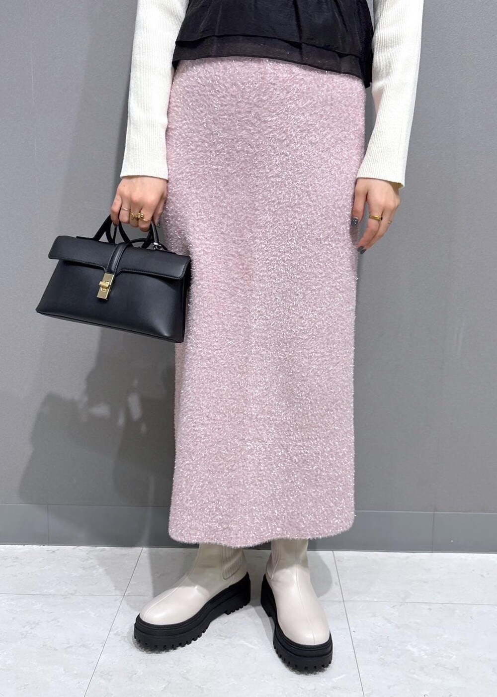 ホワイト系のブーツ、ピンク系のスカート、ホワイト系のニット/セーターを着用したレディースの冬コーディネートの7枚目の写真