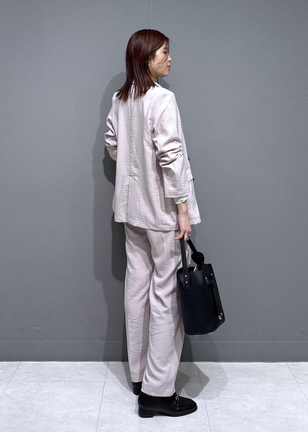 ブラック系のショルダーバッグ、ブラック系のローファー、ホワイト系のカーディガン/ボレロを着用したレディースの春コーディネートの3枚目の写真