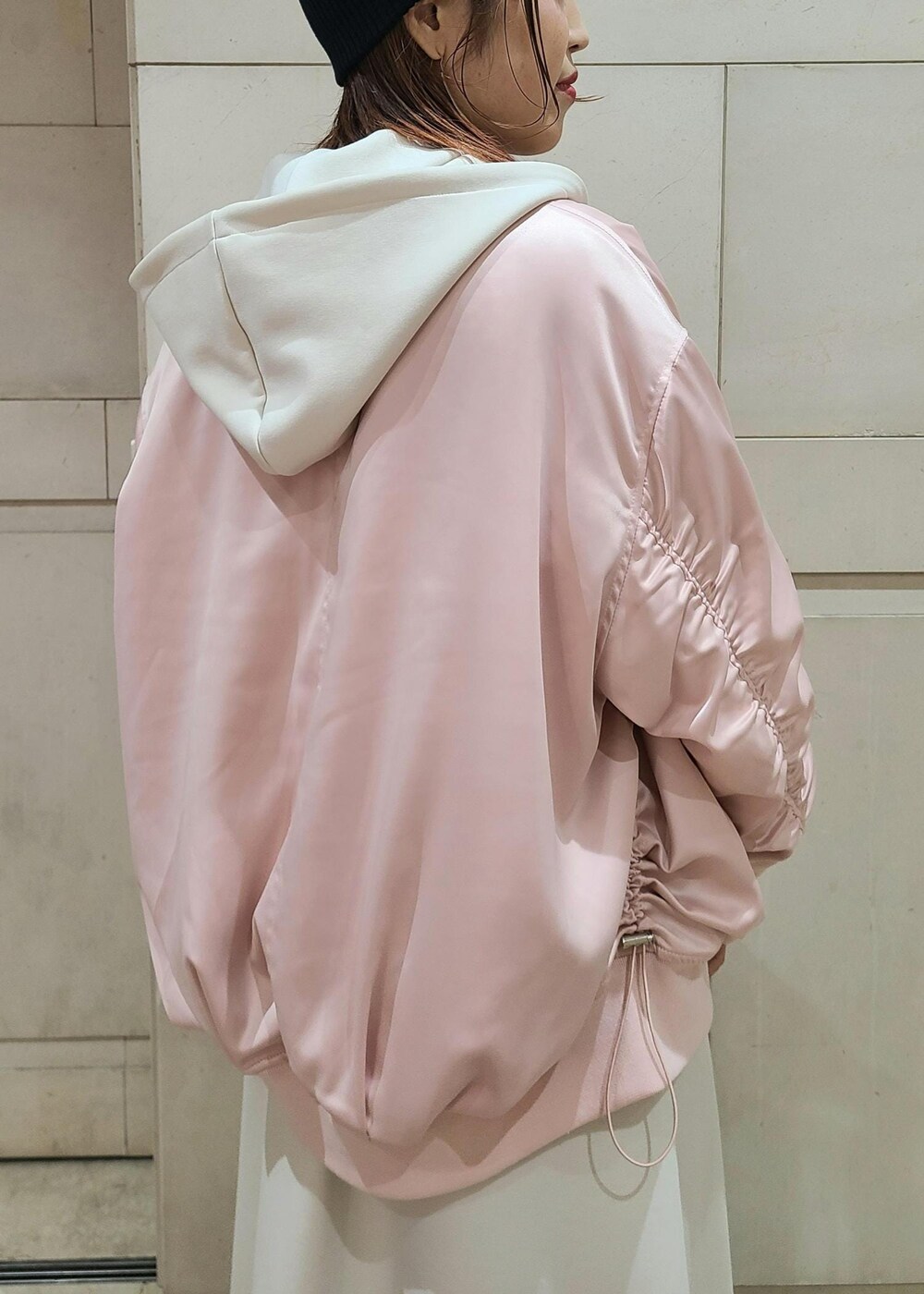 ホワイト系のハンドバッグ、ブルー系のデニムパンツ、ピンク系のブルゾンを着用したレディースの冬コーディネートの2枚目の写真