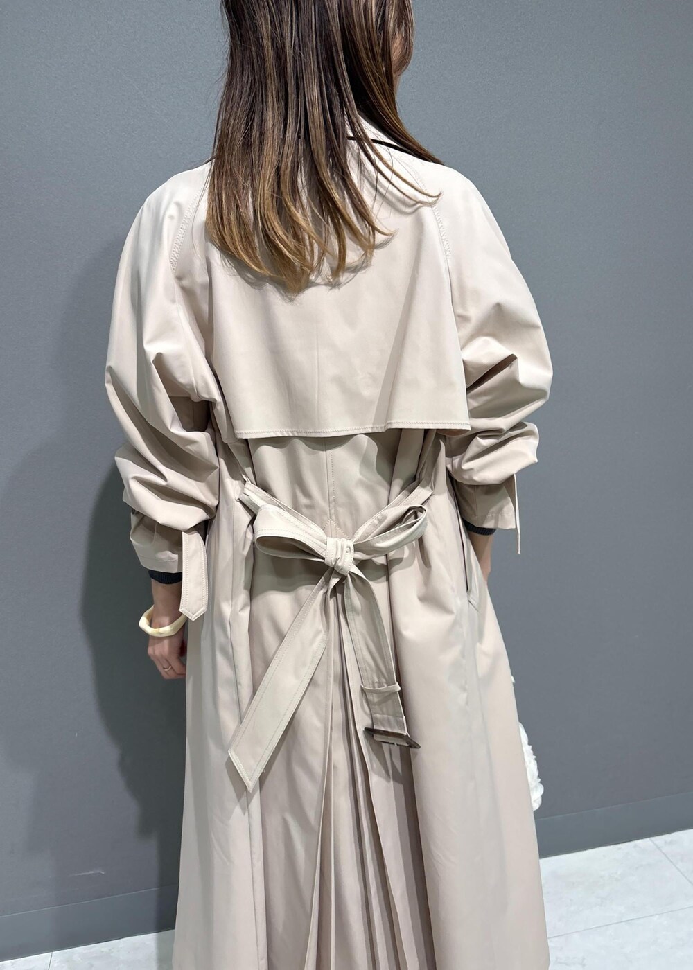 ブラック系のローファー、ブラック系のニット/セーター、ベージュ系のトレンチコートを着用したレディースの春コーディネートの5枚目の写真