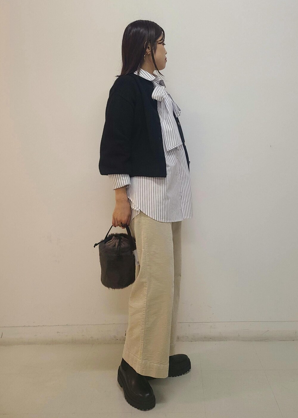 ブラック系のブーツ、グレー系のショルダーバッグ、ブラック系のカーディガン/ボレロを着用したレディースの秋コーディネートの3枚目の写真