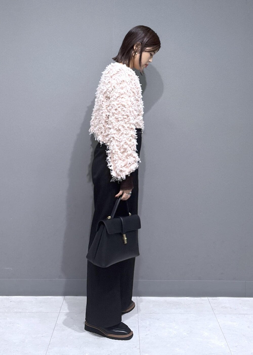 ブラック系のハンドバッグ、ブラック系のローファー、ブラウン系のTシャツ/カットソーを着用したレディースの秋コーディネートの2枚目の写真