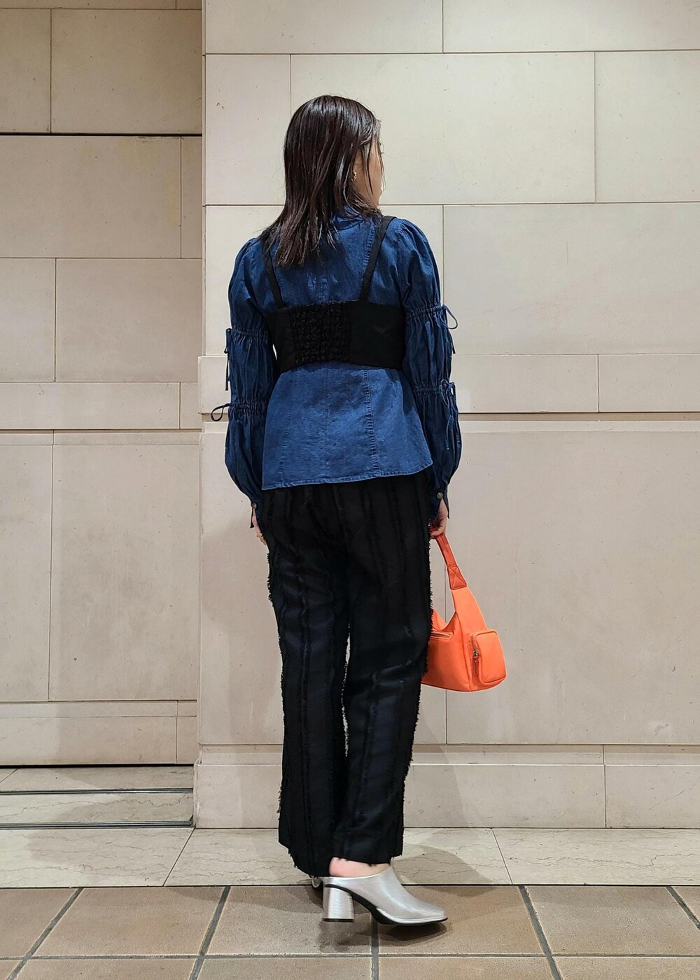 ブラック系のキャミソール、ブルー系のシャツ/ブラウス、ブラック系のスラックスを着用したレディースの春コーディネートの2枚目の写真