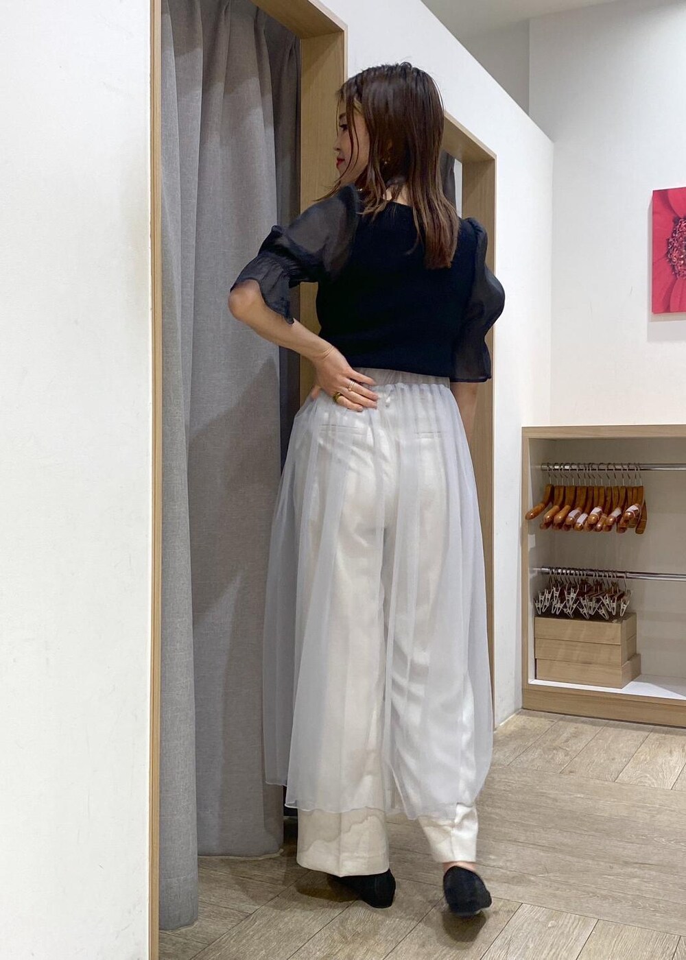 ブラック系のパンプス、グレー系のスカート、ブラック系のニット/セーターを着用したレディースの春コーディネートの2枚目の写真