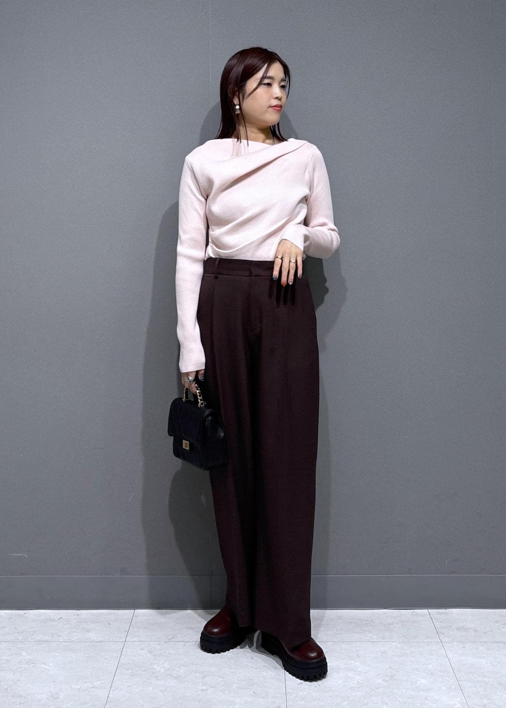 ブラウン系のスラックス、ブラウン系のブーツ、グレー系のその他アウターを着用したレディースの冬コーディネートの4枚目の写真