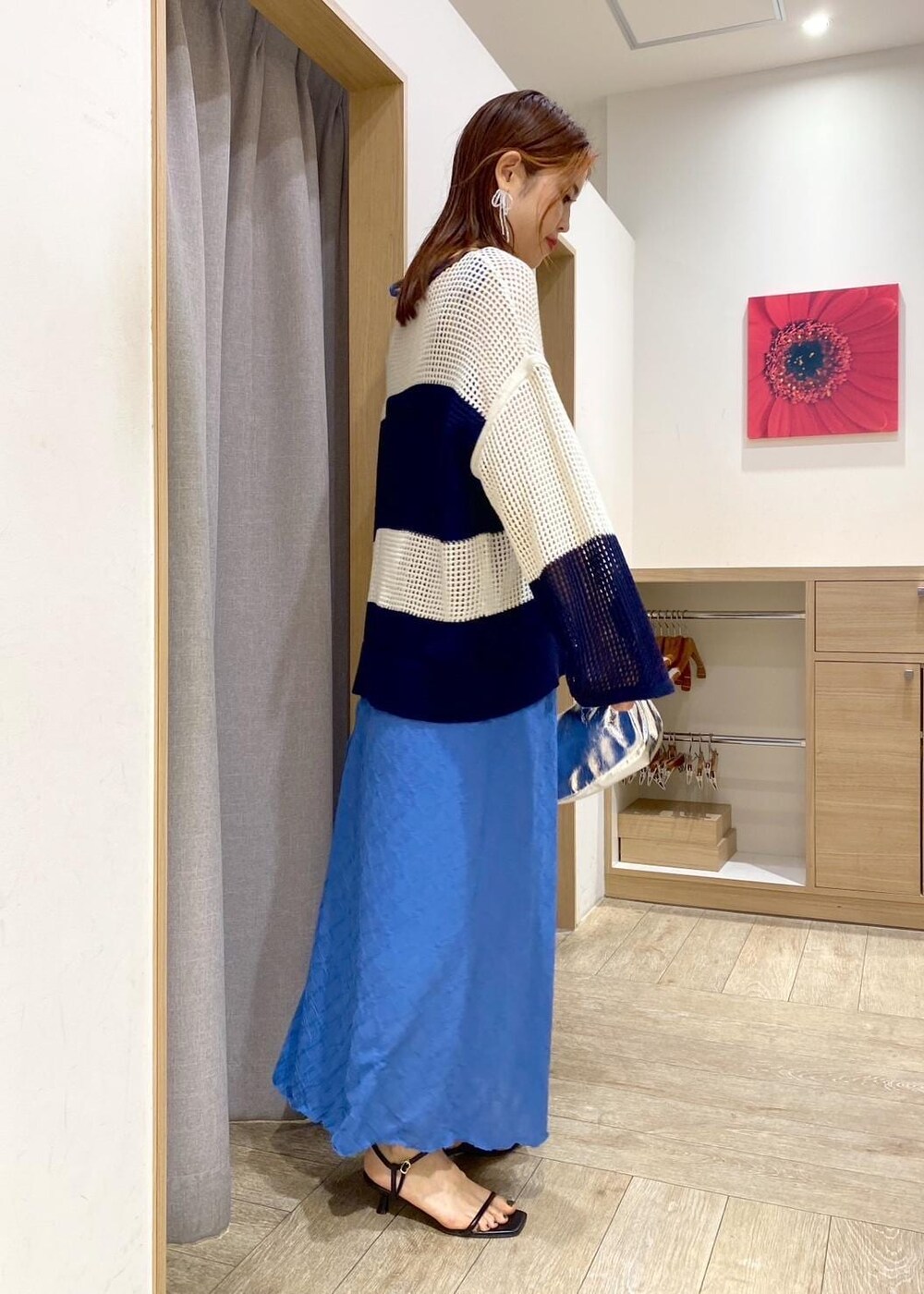 シルバー系のハンドバッグ、ブルー系のニット/セーター、ブルー系のワンピースを着用したレディースの春コーディネートの2枚目の写真