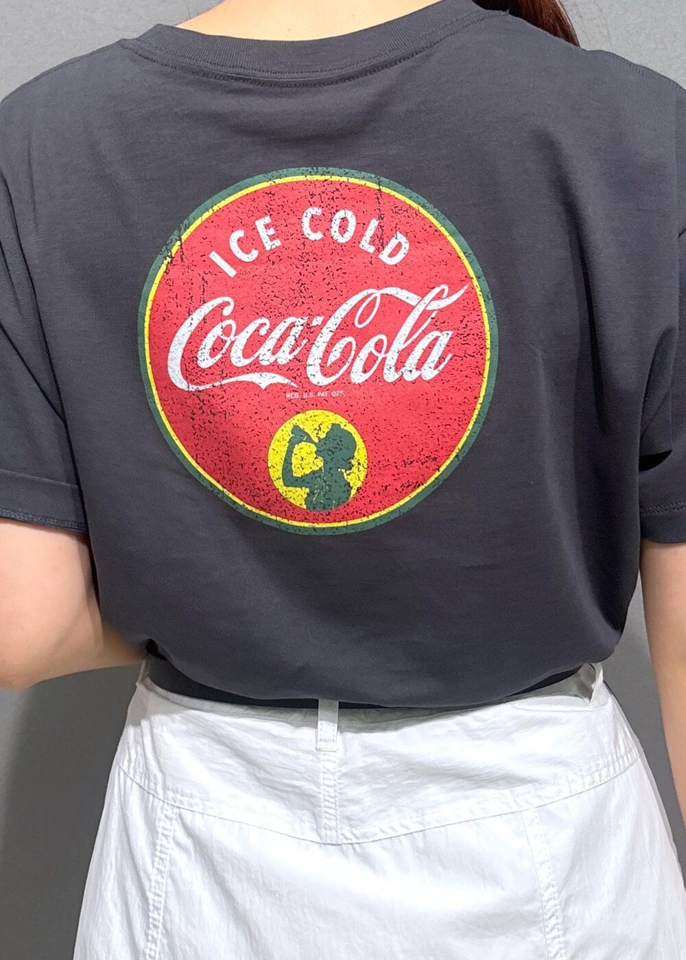 ブラック系のサンダル、グリーン系のハンドバッグ、ホワイト系のスカートを着用したレディースの夏コーディネートの5枚目の写真