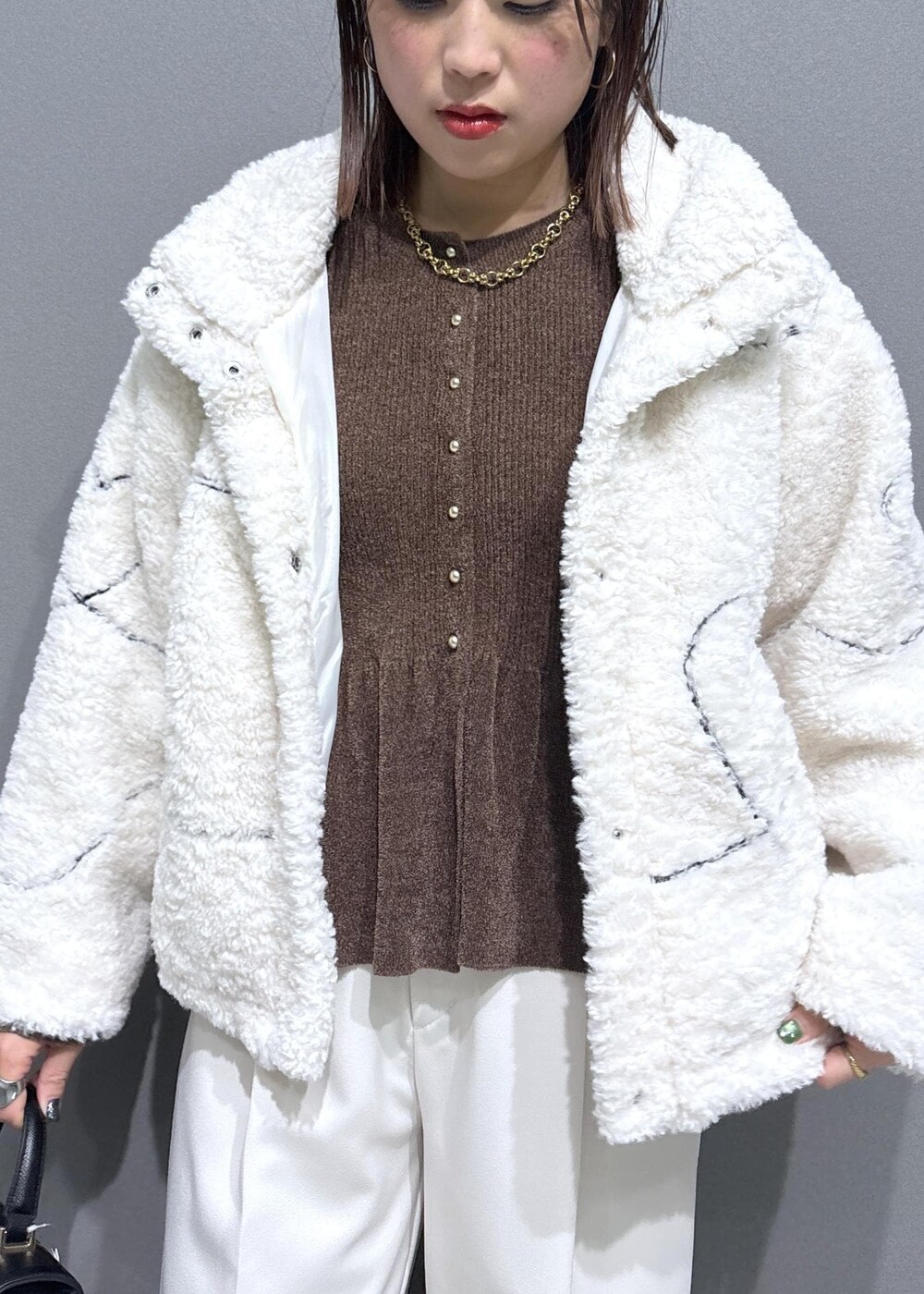 ブラック系のローファー、ホワイト系のブルゾン、ブラック系のハンドバッグを着用したレディースの冬コーディネートの6枚目の写真