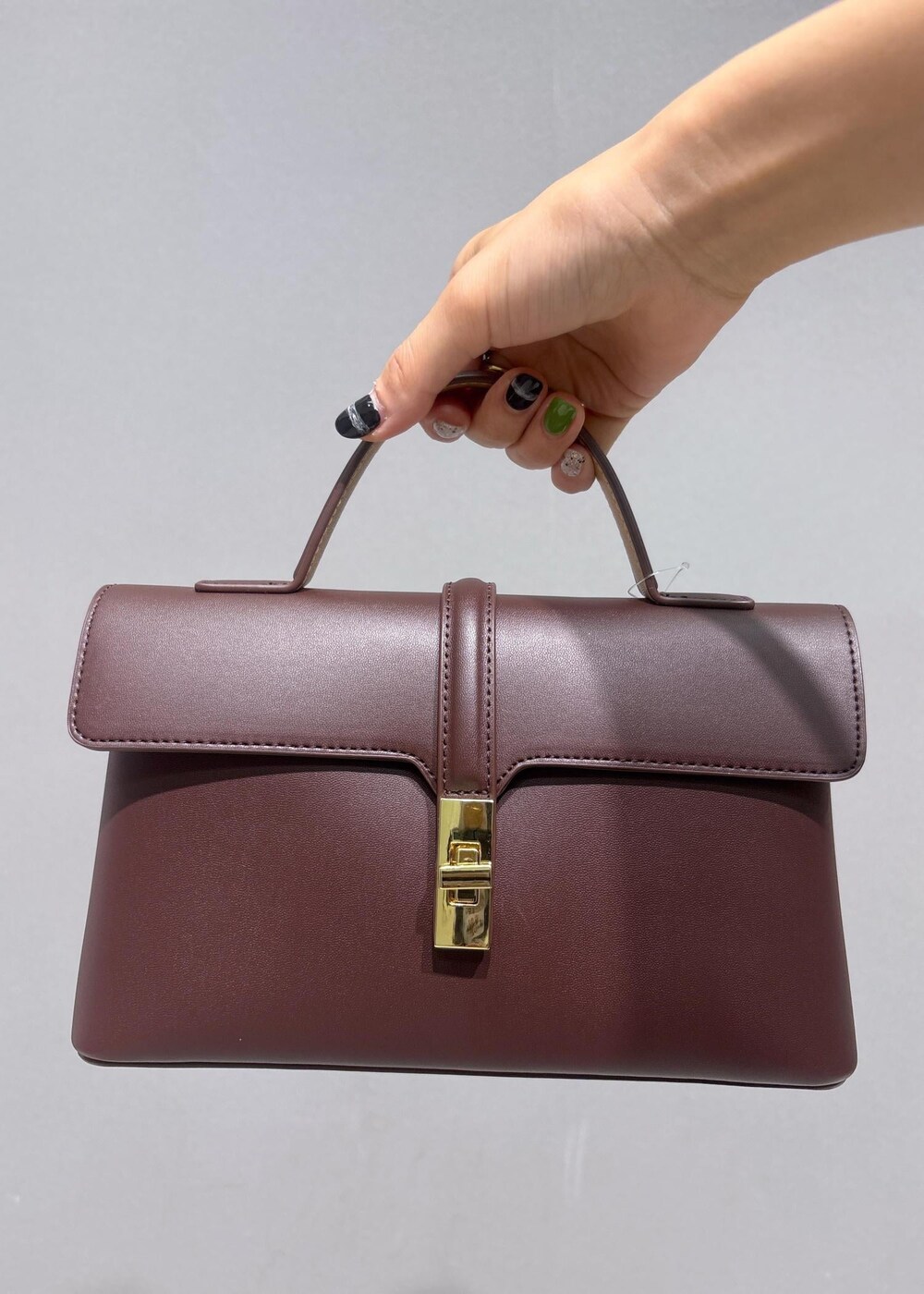 ブラウン系のショルダーバッグ、グレー系のタンクトップ、ブルー系のデニムパンツを着用したレディースの夏コーディネートの7枚目の写真