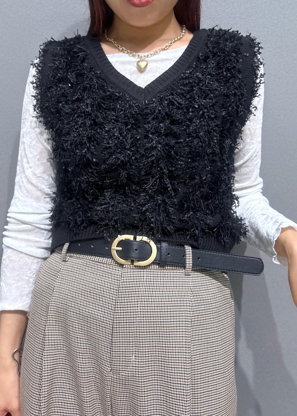 ベージュ系のスラックス、レッド系のボストンバッグ、ブラック系のベストを着用したレディースの秋コーディネートの4枚目の写真