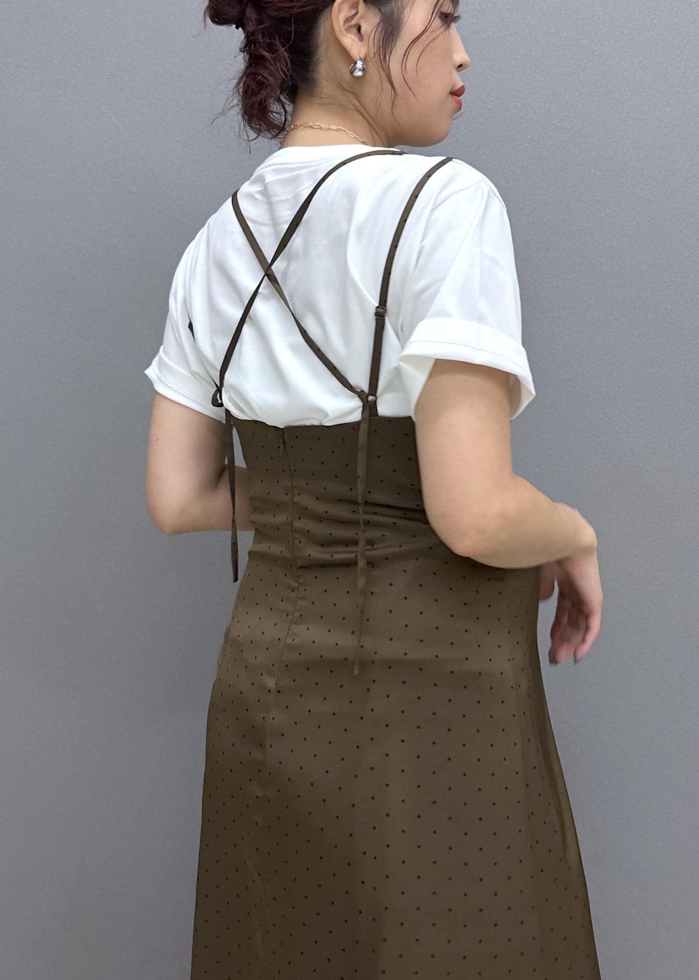 イエロー系のショルダーバッグ、ホワイト系のTシャツ/カットソー、ブラウン系のワンピースを着用したレディースの夏コーディネートの6枚目の写真