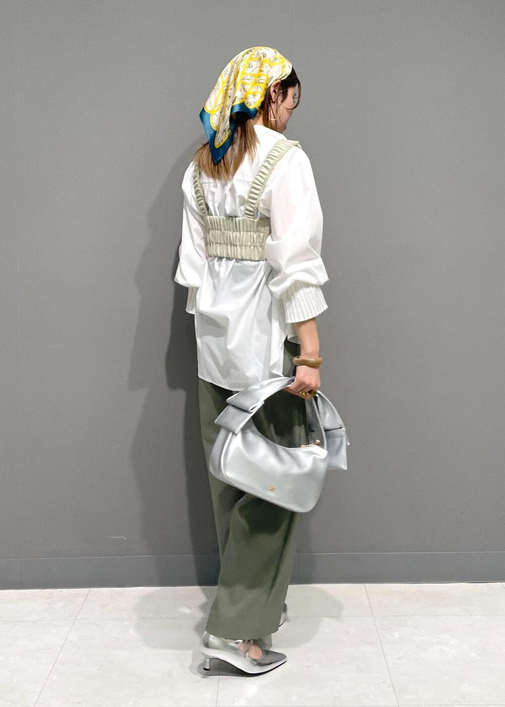 ホワイト系のシャツ/ブラウス、シルバー系のハンドバッグ、ホワイト系のベストを着用したレディースの冬コーディネートの3枚目の写真