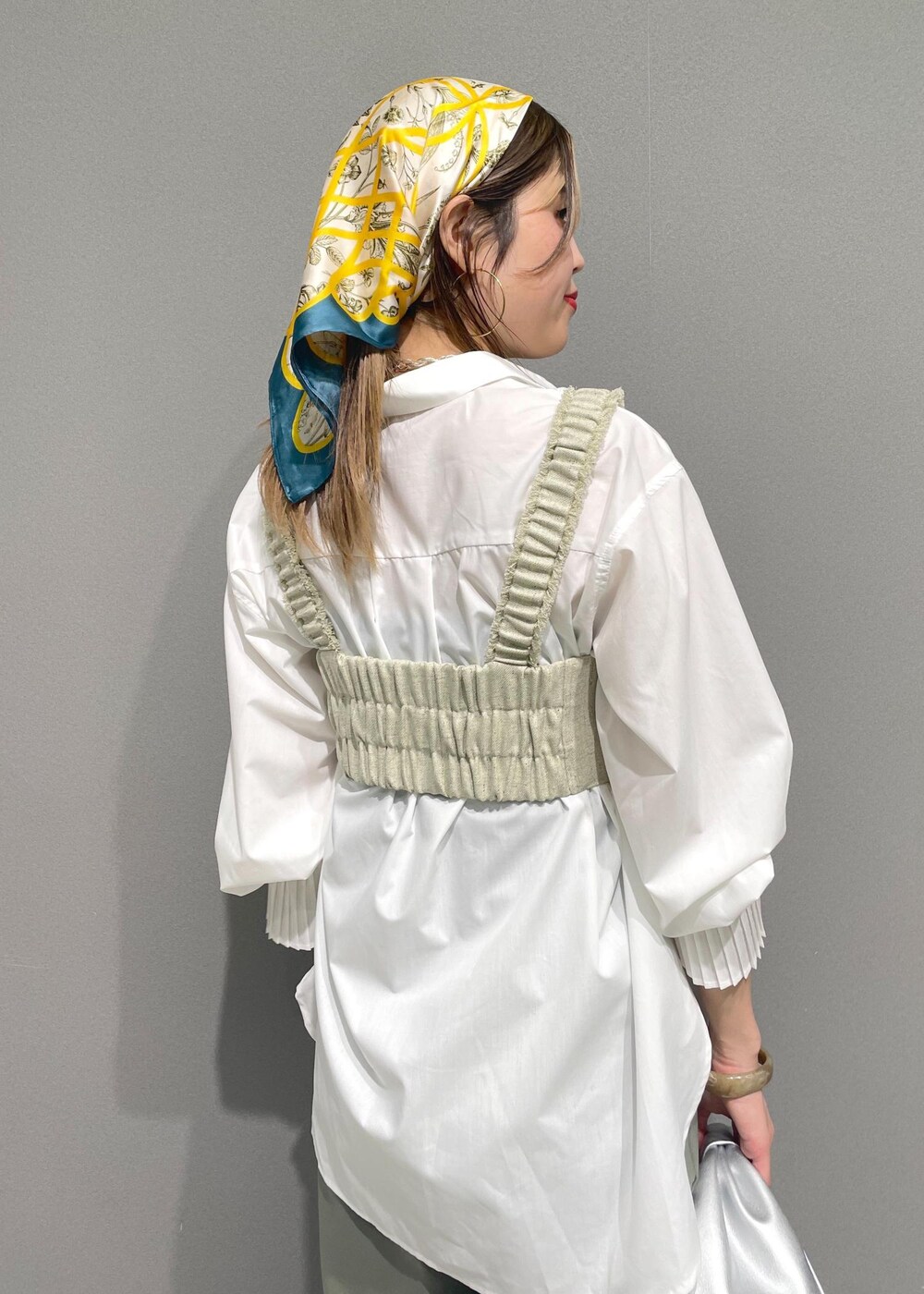 ホワイト系のシャツ/ブラウス、シルバー系のハンドバッグ、ホワイト系のベストを着用したレディースの冬コーディネートの7枚目の写真