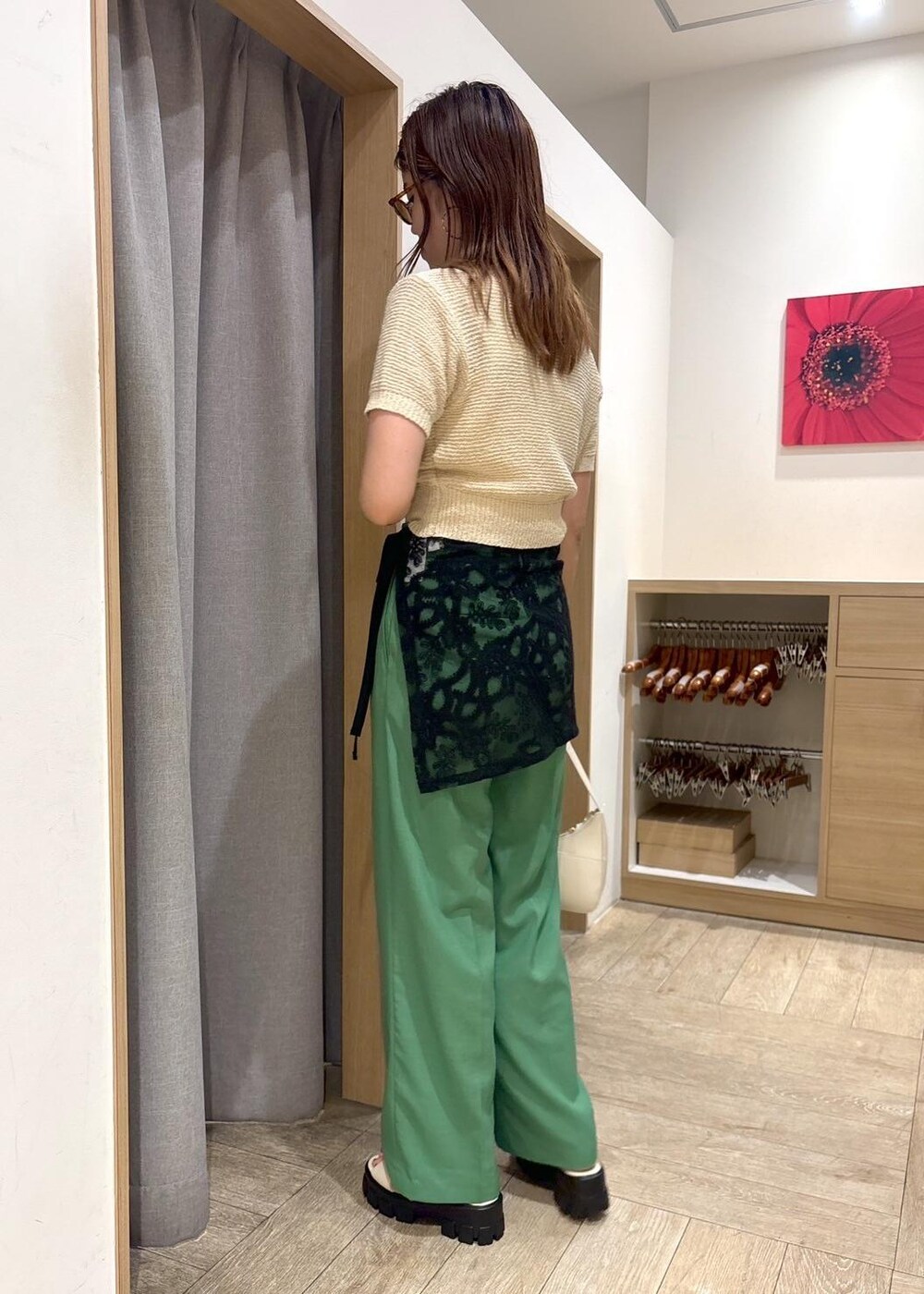 ホワイト系のハンドバッグ、ホワイト系のニット/セーター、ホワイト系のサンダルを着用したレディースの春コーディネートの3枚目の写真