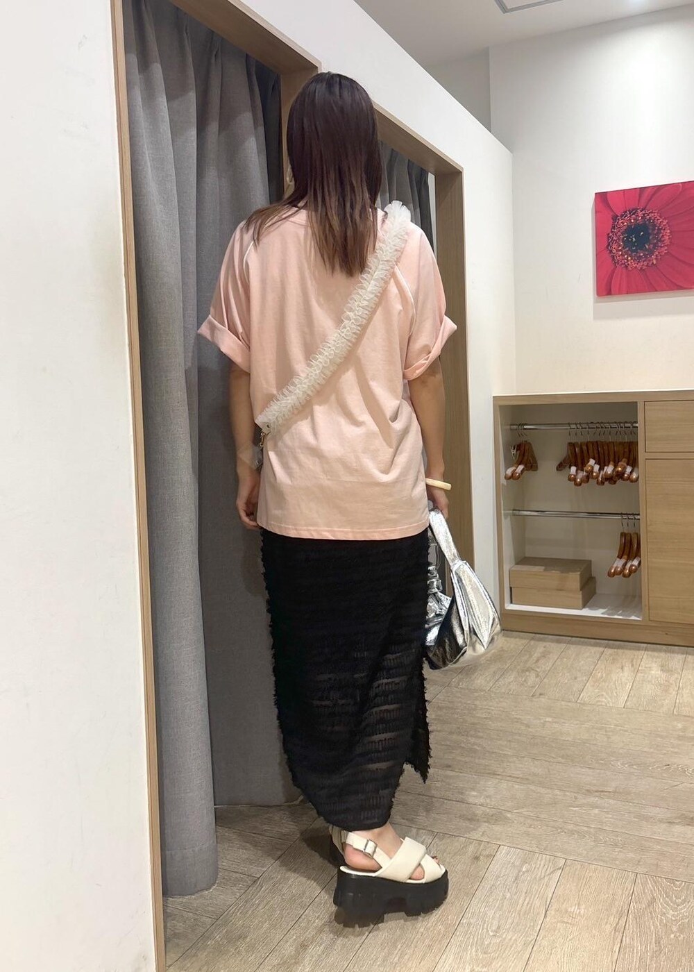 ホワイト系のサンダル、ブラック系のスカート、シルバー系のハンドバッグを着用したレディースの夏コーディネートの3枚目の写真