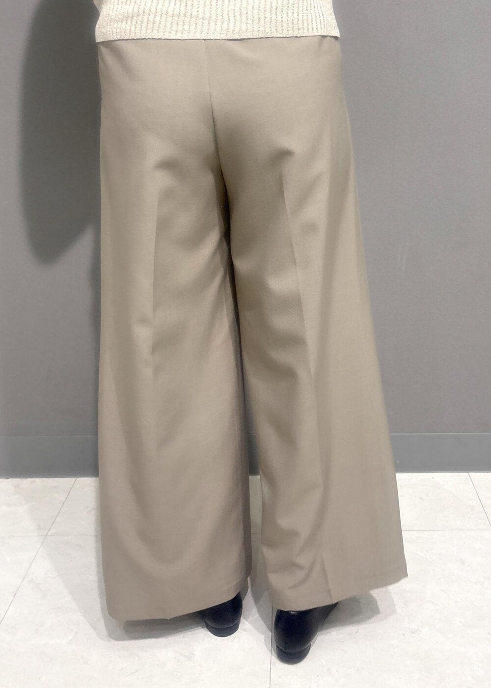 ブラック系のバレエシューズ、ベージュ系のスラックス、ホワイト系のカーディガン/ボレロを着用したレディースの夏コーディネートの8枚目の写真