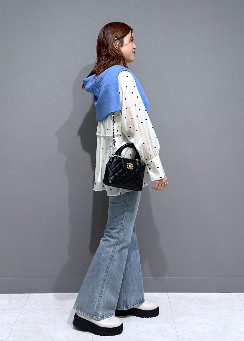 ブルー系のデニムパンツ、ホワイト系のブーツ、ベージュ系のシャツ/ブラウスを着用したレディースの冬コーディネートの2枚目の写真