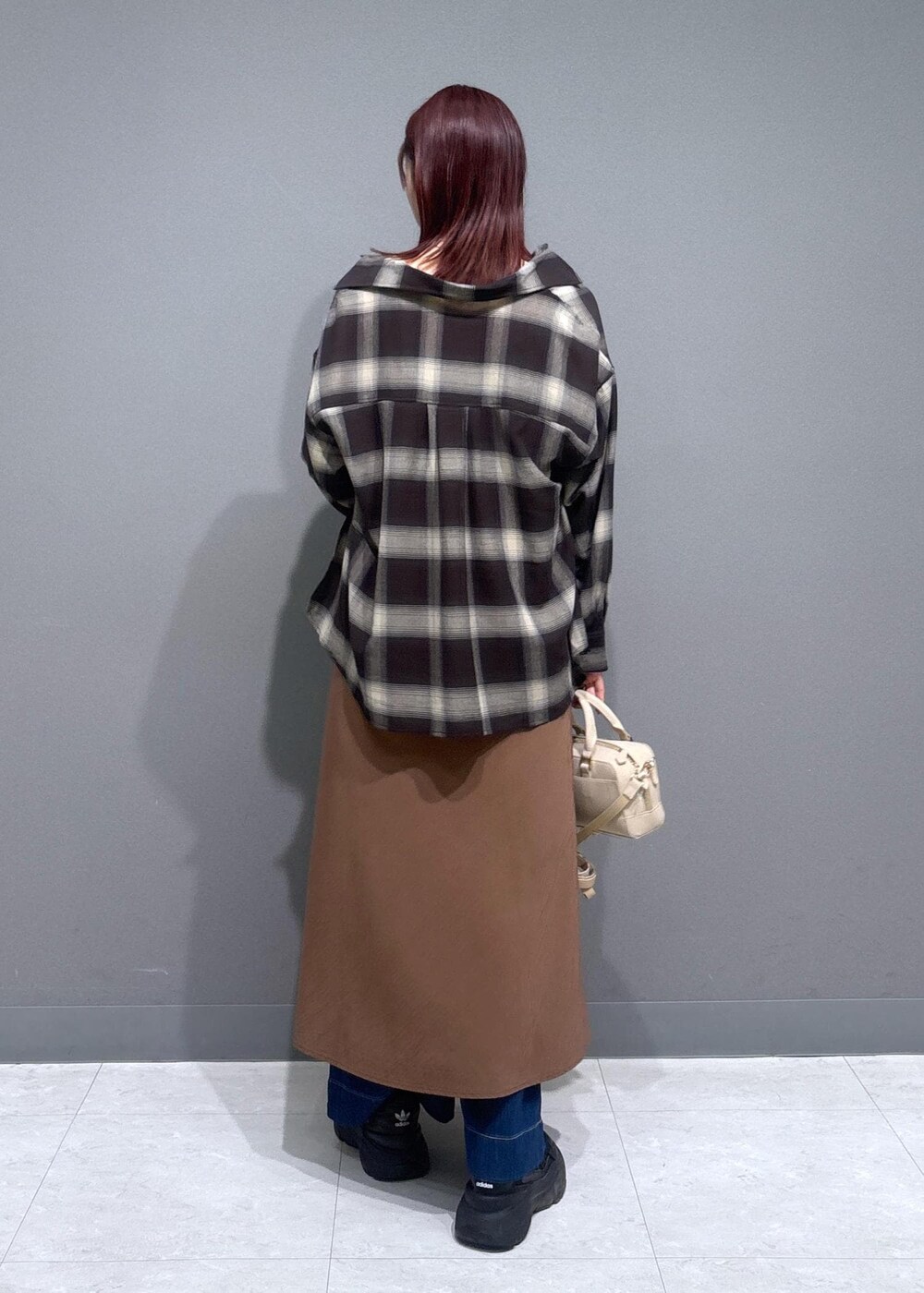 グレー系のタンクトップ、ブルー系のデニムパンツ、ブラウン系のワンピースを着用したレディースの夏コーディネートの3枚目の写真