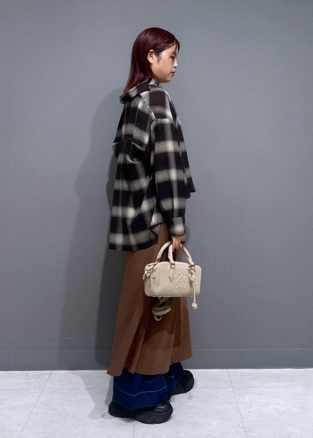 グレー系のタンクトップ、ブルー系のデニムパンツ、ブラウン系のワンピースを着用したレディースの夏コーディネートの2枚目の写真