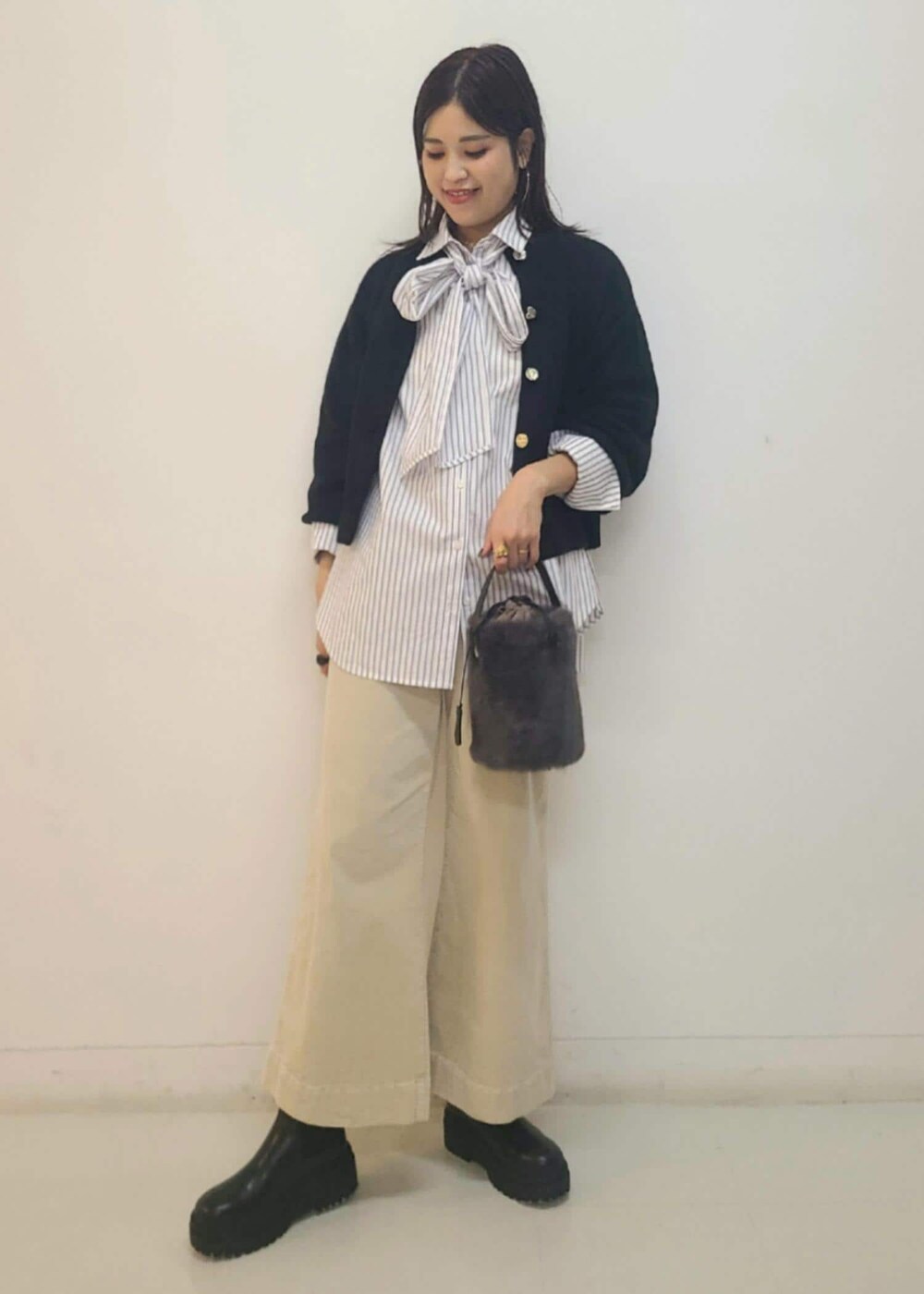 ブラック系のブーツ、グレー系のショルダーバッグ、ブラック系のカーディガン/ボレロを着用したレディースの秋コーディネートの2枚目の写真