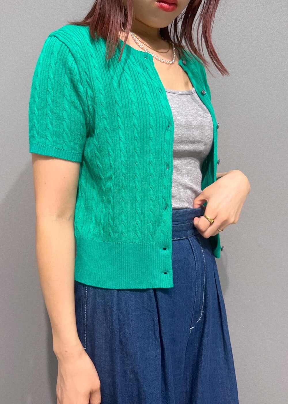 ブラウン系のショルダーバッグ、グレー系のタンクトップ、ブルー系のデニムパンツを着用したレディースの夏コーディネートの4枚目の写真