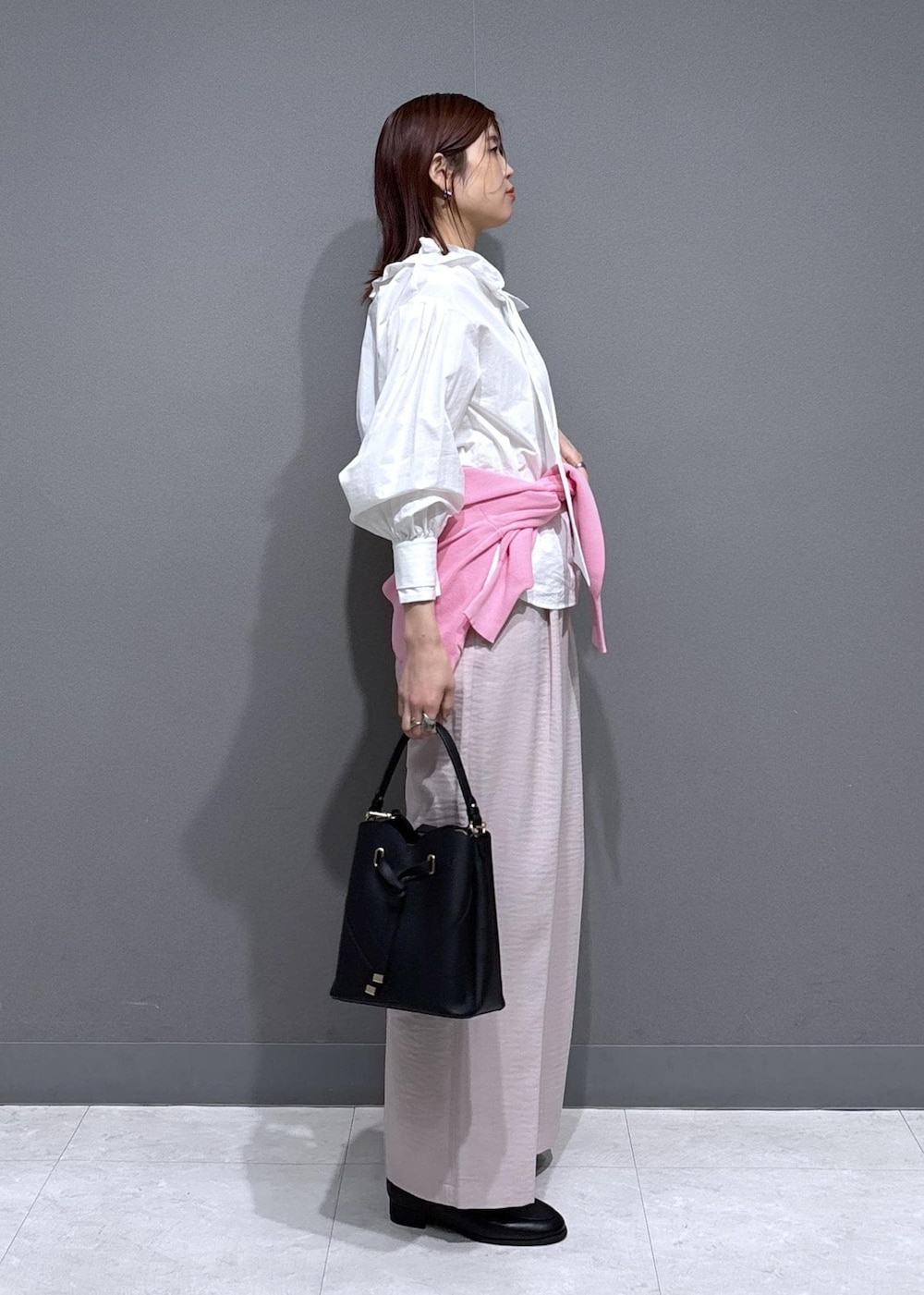 ブラック系のショルダーバッグ、ブラック系のローファー、ピンク系のカーディガン/ボレロを着用したレディースの春コーディネートの3枚目の写真