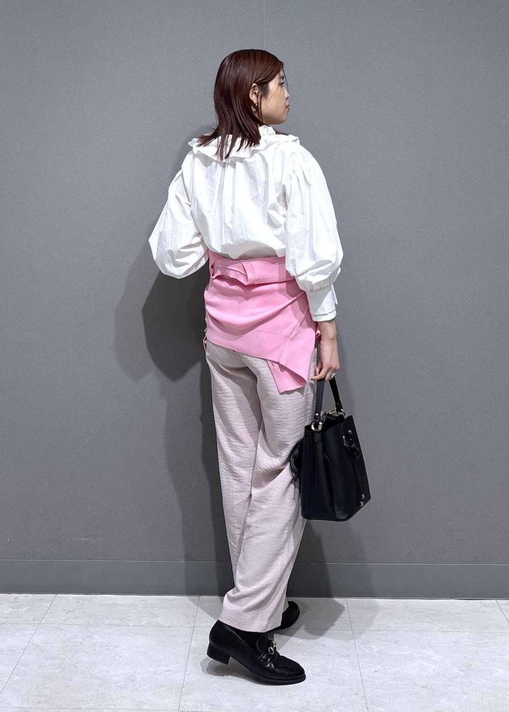 ブラック系のショルダーバッグ、ブラック系のローファー、ピンク系のカーディガン/ボレロを着用したレディースの春コーディネートの4枚目の写真