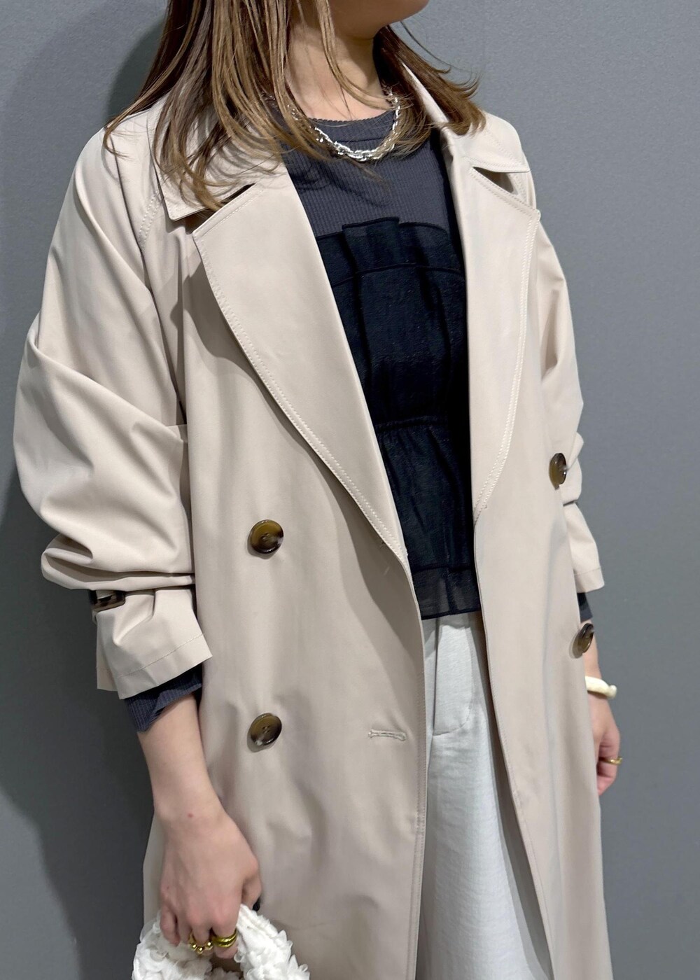 ブラック系のローファー、ブラック系のニット/セーター、ベージュ系のトレンチコートを着用したレディースの春コーディネートの4枚目の写真