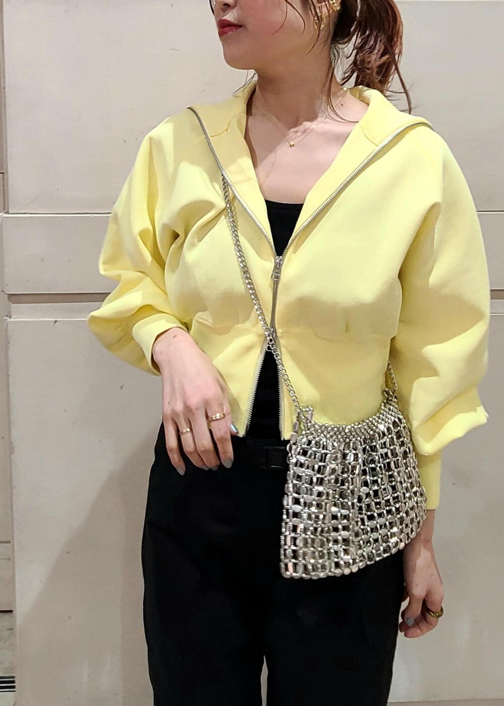 イエロー系のカーディガン/ボレロ、シルバー系のショルダーバッグ、ブラック系のカーゴパンツを着用したレディースの冬コーディネートの3枚目の写真