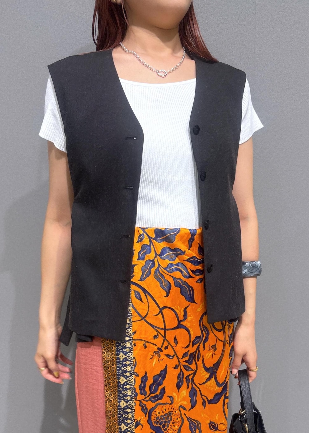 ブラック系のサンダル、ホワイト系のニット/セーター、オレンジ系のスラックスを着用したレディースの夏コーディネートの4枚目の写真