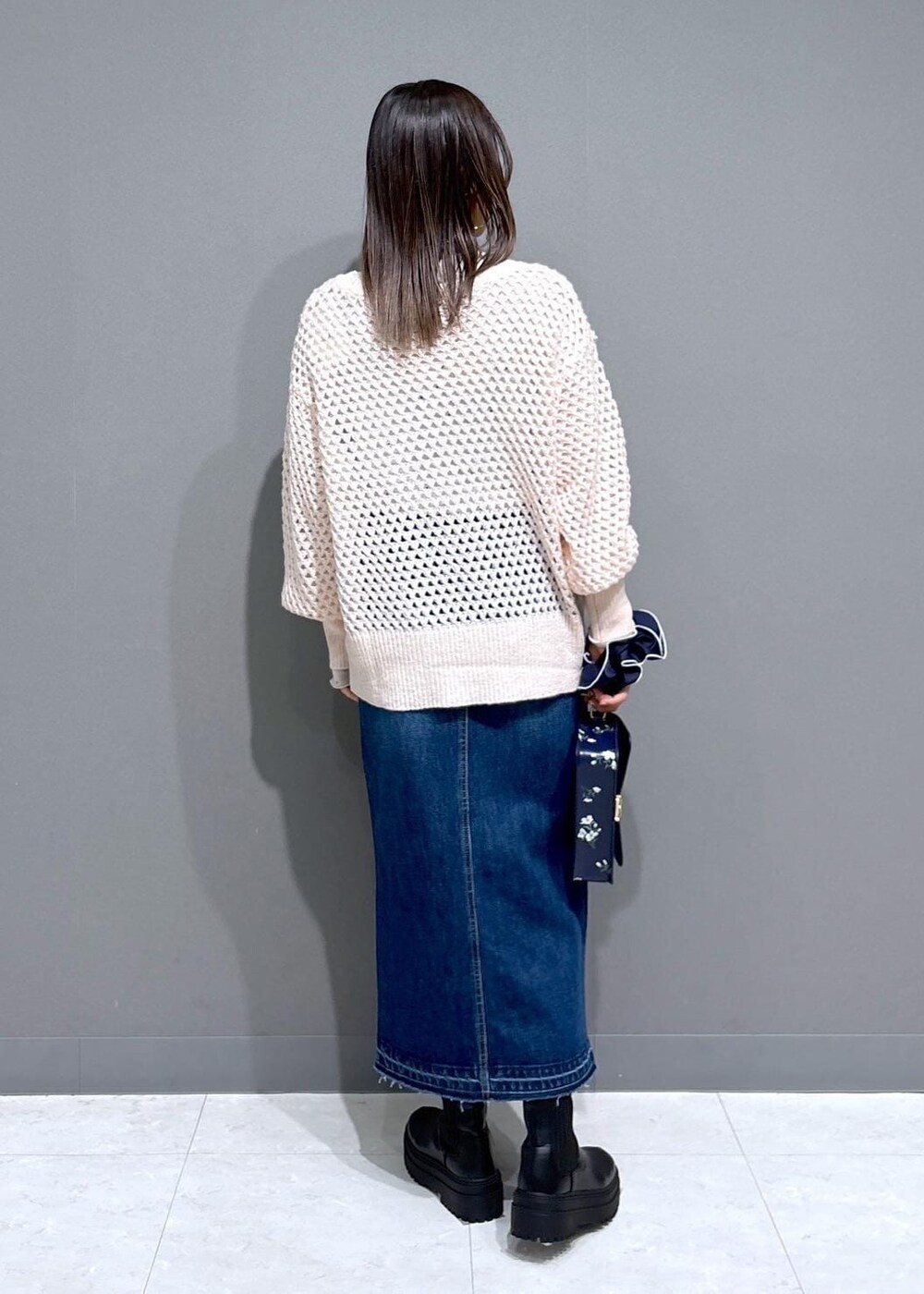 ブラック系のブーツ、ホワイト系のTシャツ/カットソー、ピンク系のニット/セーターを着用したレディースの冬コーディネートの4枚目の写真