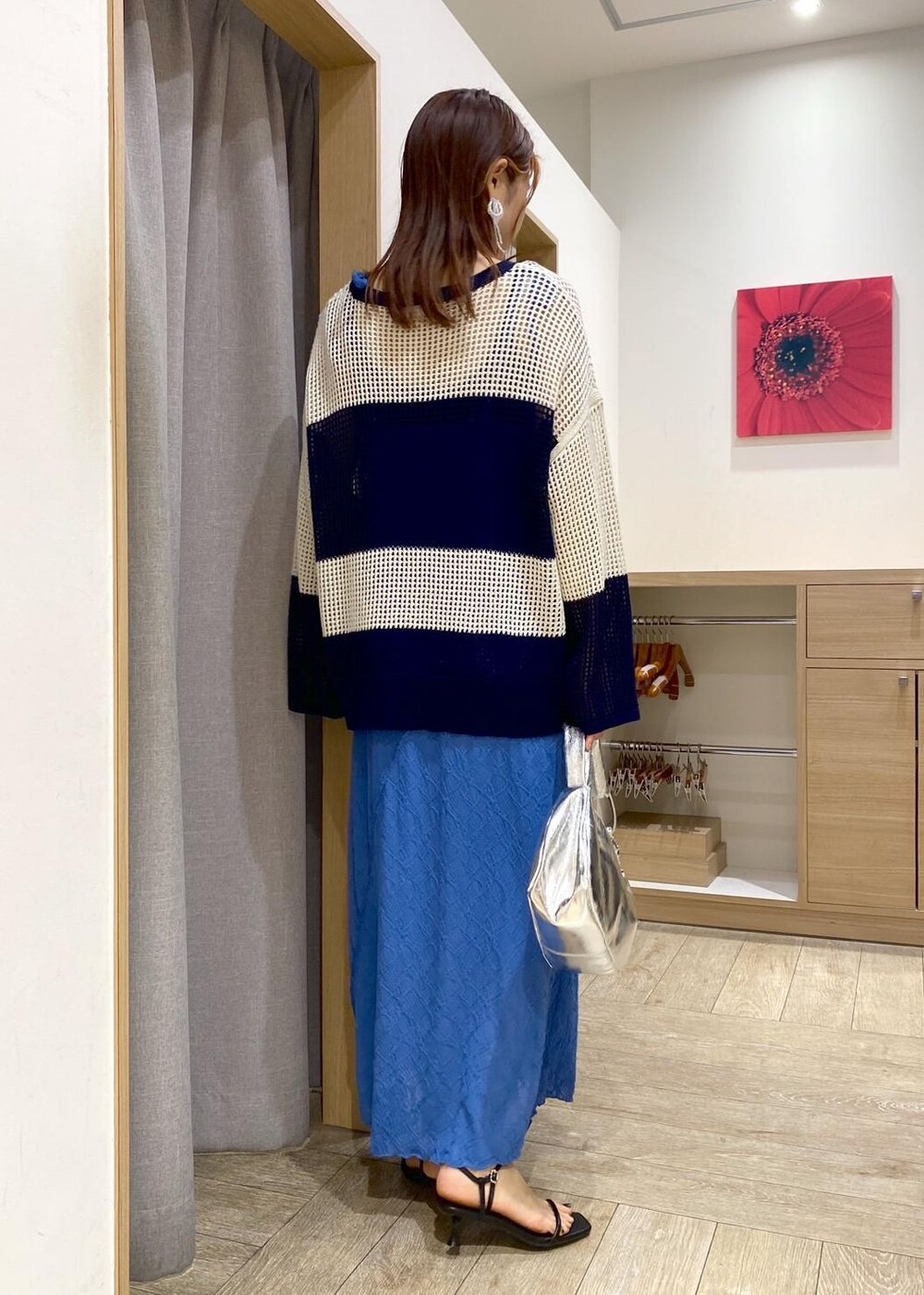 シルバー系のハンドバッグ、ブルー系のニット/セーター、ブルー系のワンピースを着用したレディースの春コーディネートの3枚目の写真