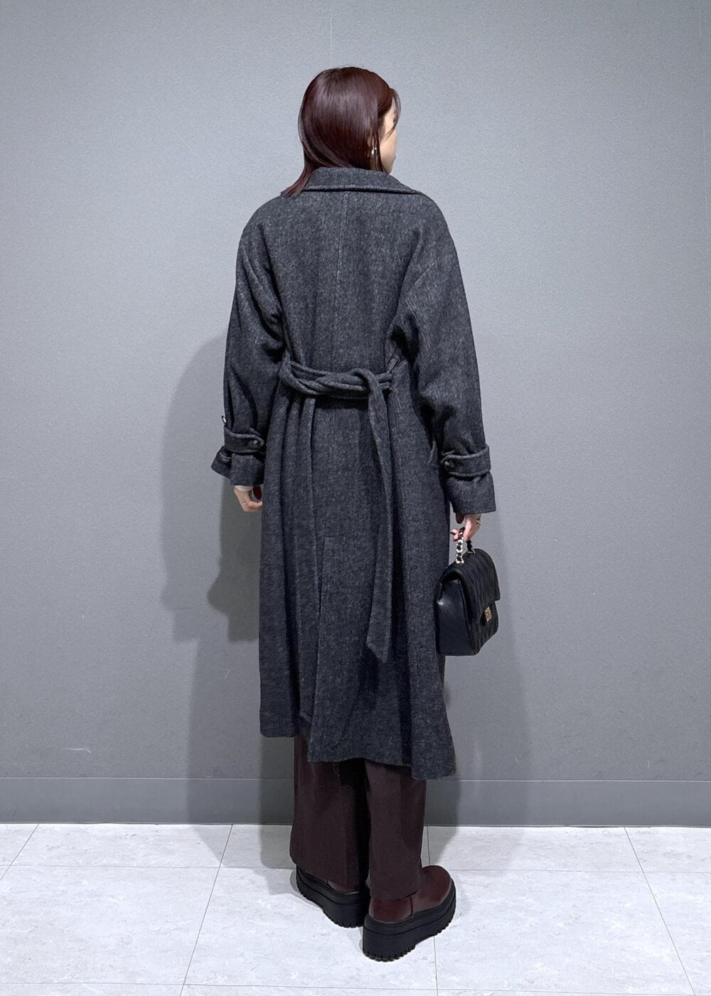 ブラウン系のスラックス、ブラウン系のブーツ、グレー系のその他アウターを着用したレディースの冬コーディネートの3枚目の写真