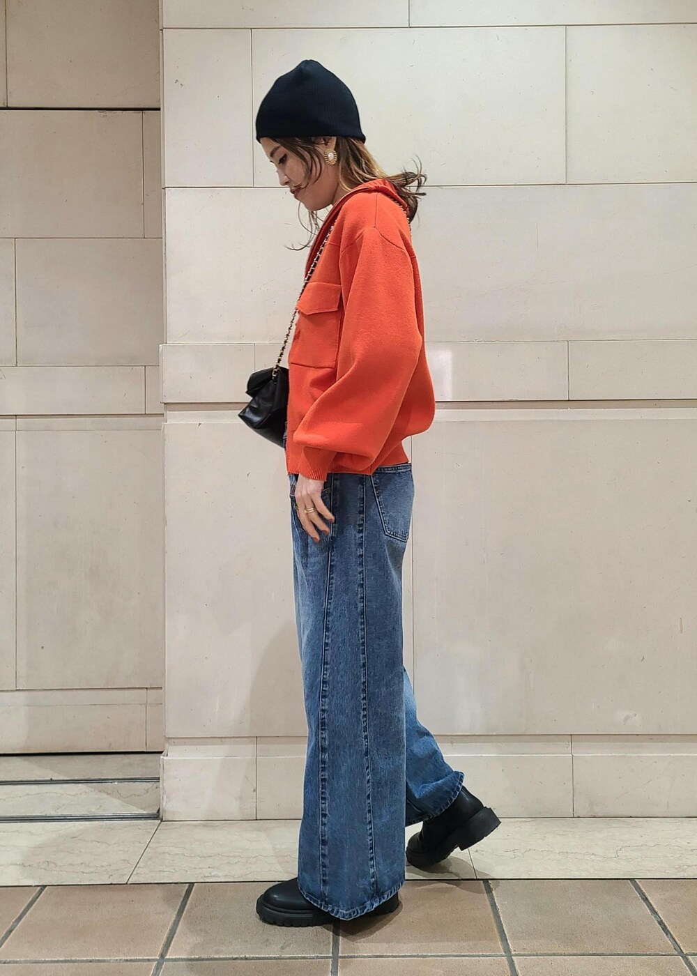ホワイト系のTシャツ/カットソー、オレンジ系のカーディガン/ボレロ、ブルー系のデニムパンツを着用したレディースの冬コーディネートの2枚目の写真