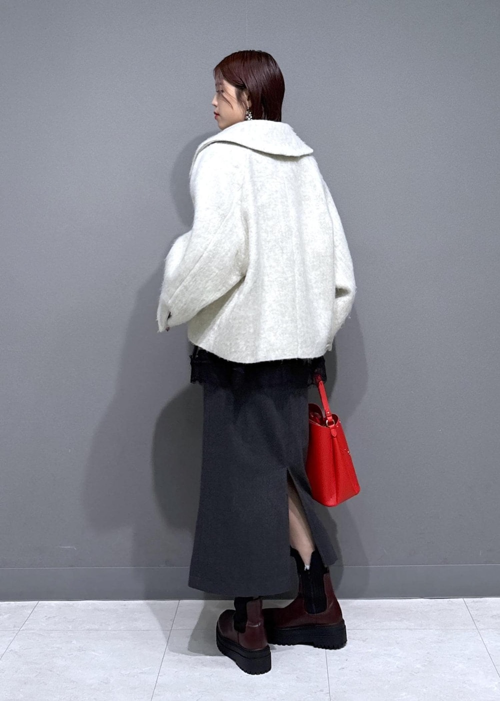 ブラウン系のブーツ、ホワイト系のブルゾン、ホワイト系のTシャツ/カットソーを着用したレディースの冬コーディネートの3枚目の写真