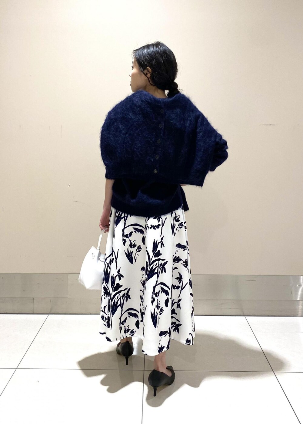 ブラック系のパンプス、ホワイト系のハンドバッグ、ホワイト系のスカートを着用したレディースの冬コーディネートの5枚目の写真