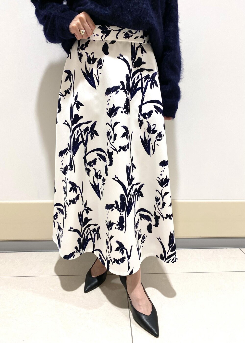 ブラック系のパンプス、ホワイト系のハンドバッグ、ホワイト系のスカートを着用したレディースの冬コーディネートの7枚目の写真