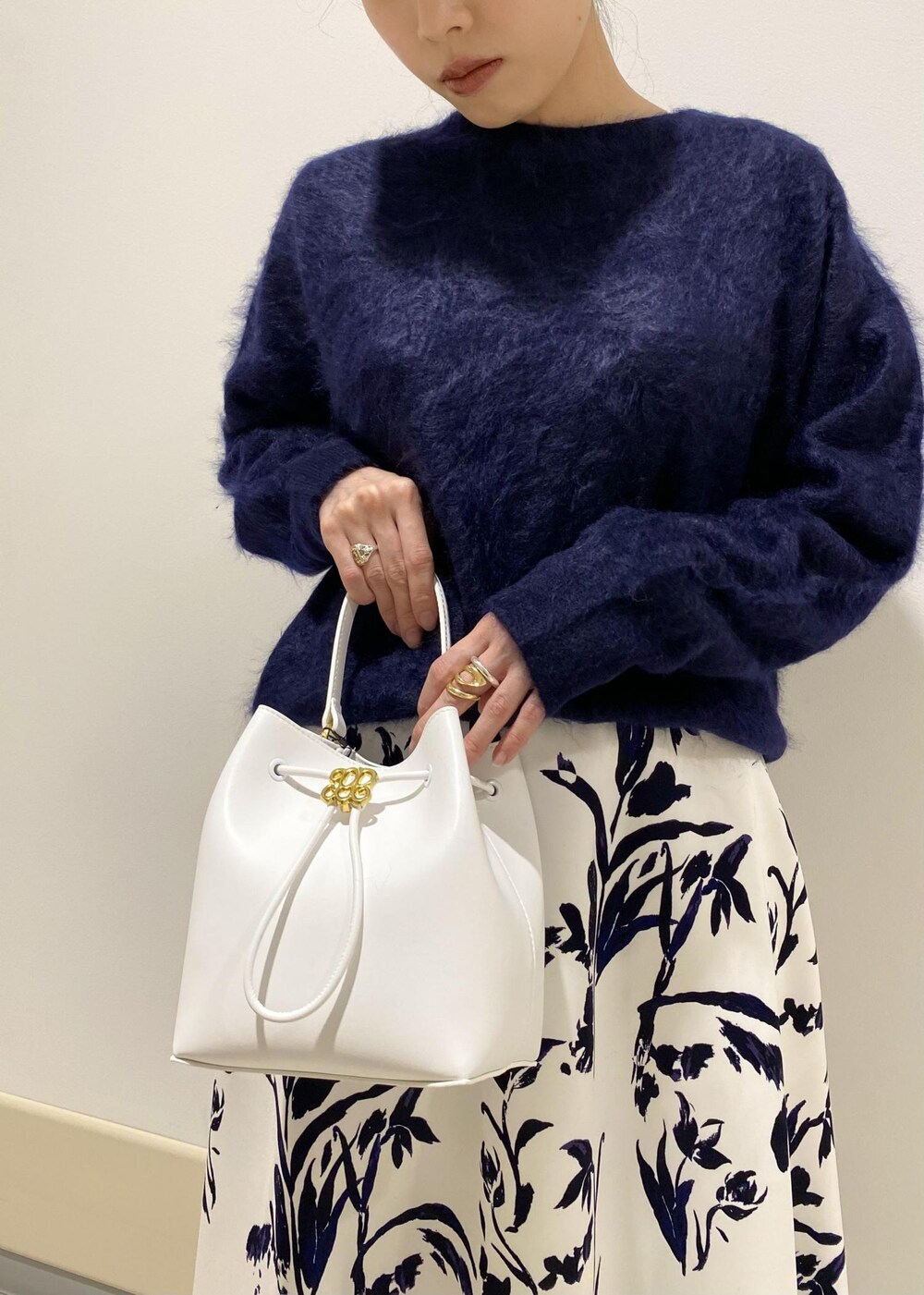 ブラック系のパンプス、ホワイト系のハンドバッグ、ホワイト系のスカートを着用したレディースの冬コーディネートの8枚目の写真