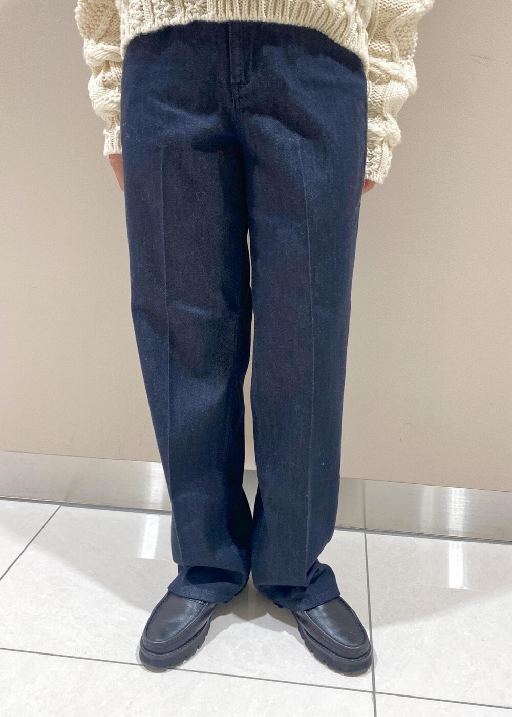 ブルー系のデニムパンツ、ブラック系のハンドバッグ、ホワイト系のニット/セーターを着用したレディースの秋コーディネートの5枚目の写真