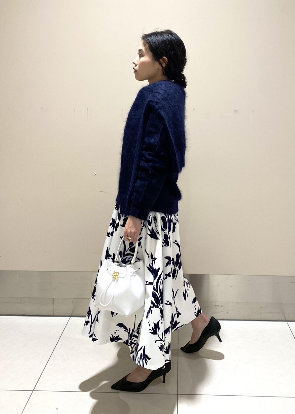 ブラック系のパンプス、ホワイト系のハンドバッグ、ホワイト系のスカートを着用したレディースの冬コーディネートの4枚目の写真