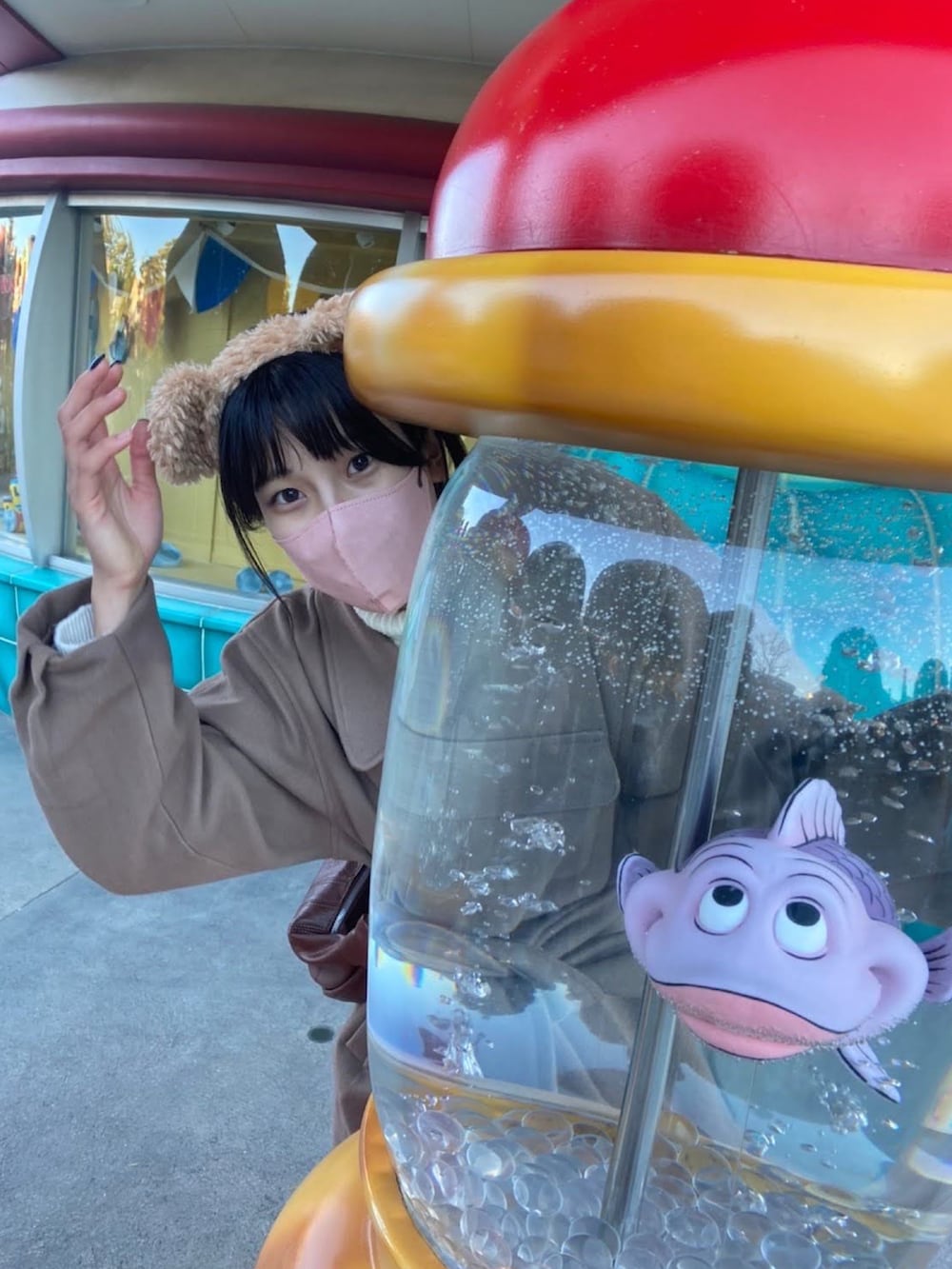 ブラウン系のステンカラーコート、ベージュ系のニット/セーター、ブラウン系のショルダーバッグを着用したレディースの秋コーディネートの5枚目の写真