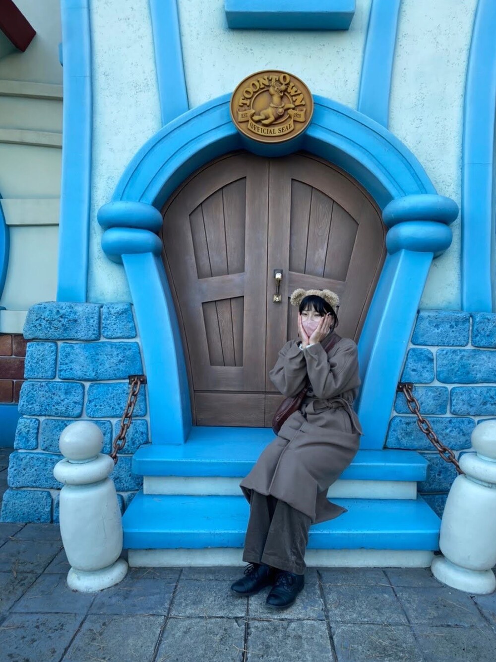 ブラウン系のステンカラーコート、ベージュ系のニット/セーター、ブラウン系のショルダーバッグを着用したレディースの秋コーディネートの4枚目の写真