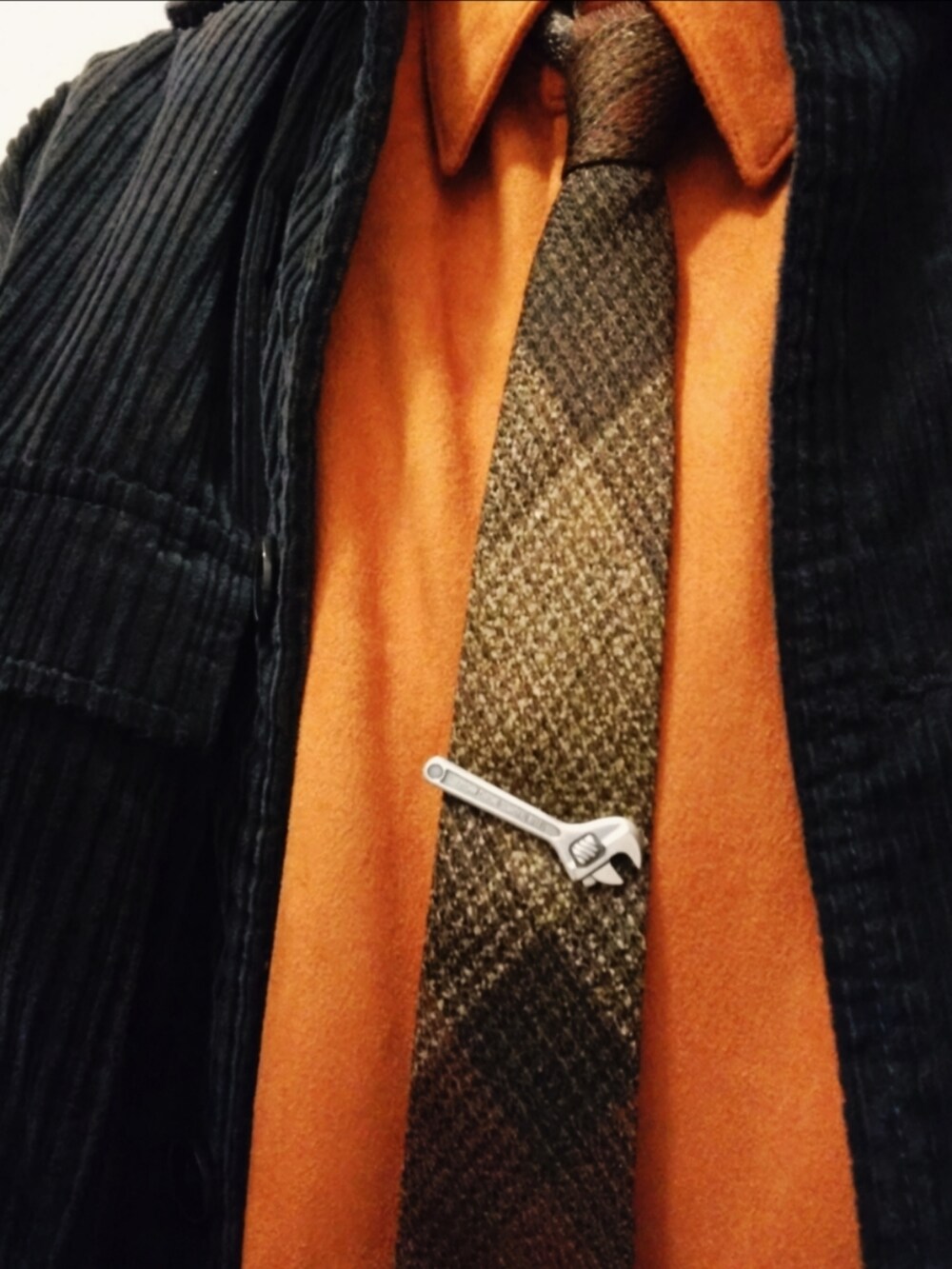 ブラック系のパンツ、ブラック系のジャケット/アウター、オレンジ系のシャツ/ブラウスを着用したメンズの冬コーディネートの2枚目の写真