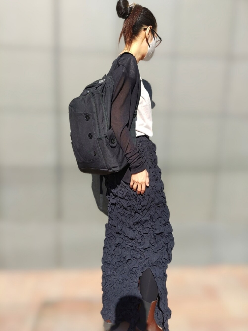 ホワイト系のTシャツ/カットソー、ブラック系のスカート、ブラウン系のブーツを着用したレディースの春コーディネートの3枚目の写真