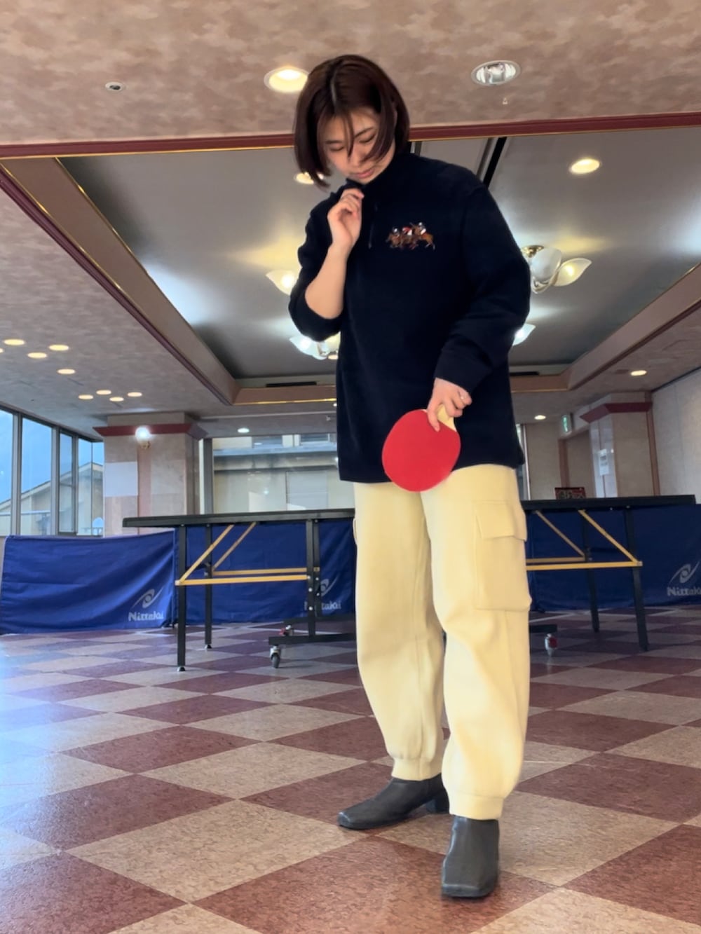 ベージュ系のカーゴパンツ、グレー系のブーツ、ブルー系のニット/セーターを着用したレディースの春コーディネートの2枚目の写真